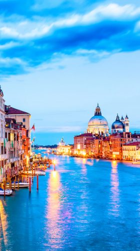 Basilica Santa Maria della Salute, Punta della Dogona and Grand Canal at blue hour sunset in Venice, Italy with boats and reflections